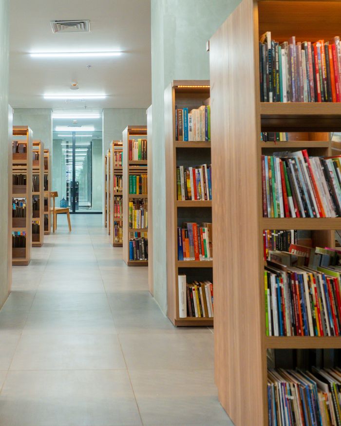services-03 Spacious library interior with neatly arranged bookshelves in Jakarta.